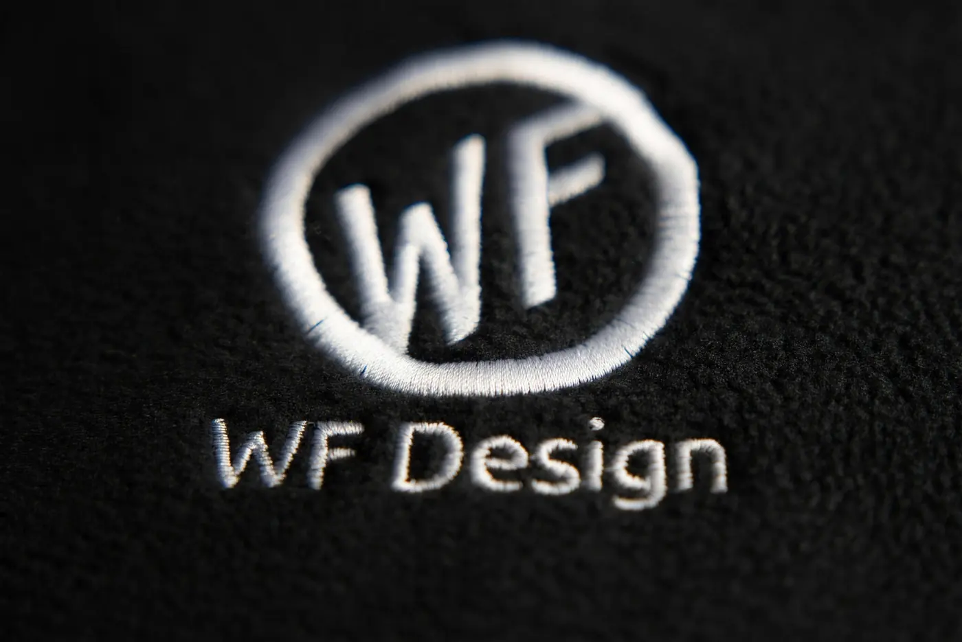 Gesticktes WF Design Logo auf schwarzem Textil